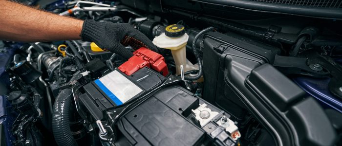 Person checking the car battery under bonnet